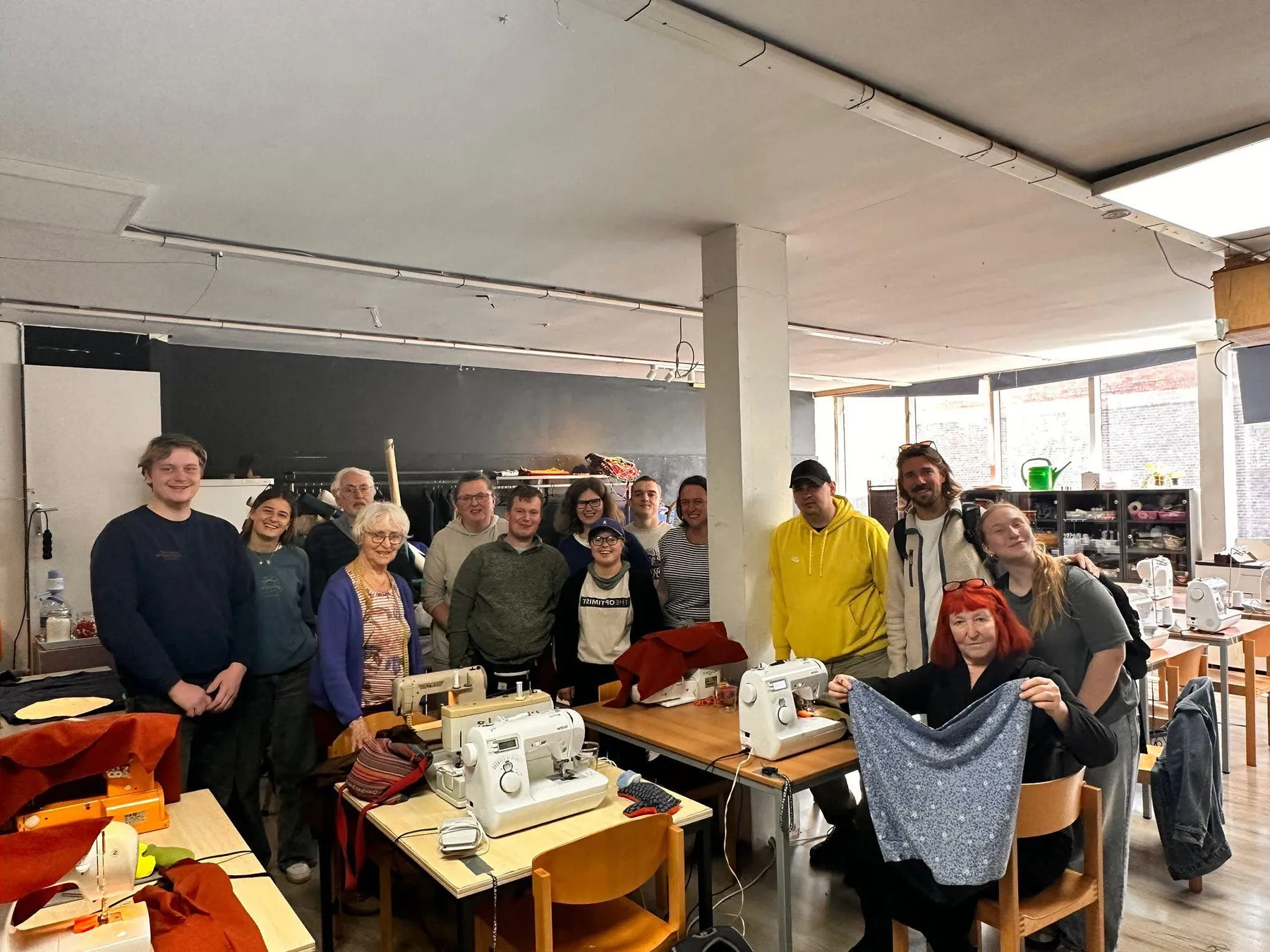 Bezoekers en vrijwilligers samen in het naaiatelier van De Rode Lotus