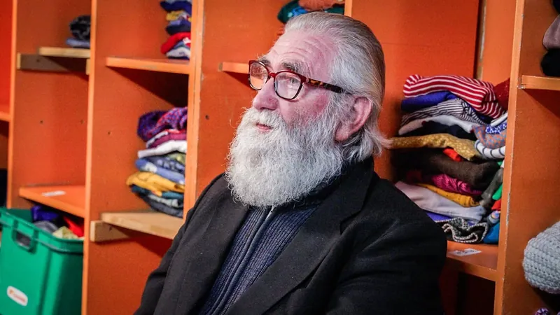 Bezoeker bij de rekken met kledij in de weggeefwinkel
